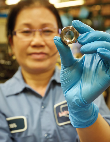 A Lok-Mor Fastener Manufacturing Employee inspects a Locknut